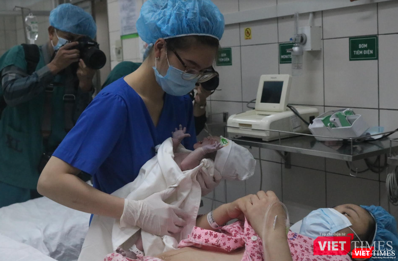 Y tá đưa bé đi cân