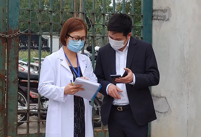 Nhân viên y tế làm việc bên ngoài cổng Trường Tiểu học Xuân Phương vào chiều qua (1/2) (Ảnh - Khánh Linh) 
