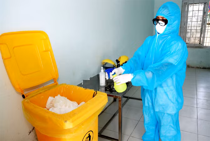 Nhân viên y tế xử lý rác ở khu cách ly (Ảnh - BYT)