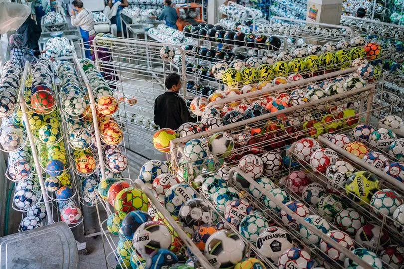 Công nhân thu thập và kiểm tra những quả bóng đã hoàn thành tại một nhà máy ở thị trấn nhỏ Sialkot (Ảnh: Bloomberg)