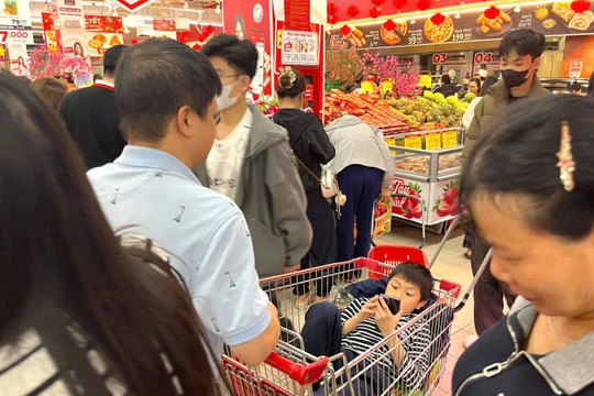 Vị khách nhí nằm chơi điện thoại trong lúc chờ bố mẹ mua hàng, hình ảnh quen thuộc trong những dịp Tết.