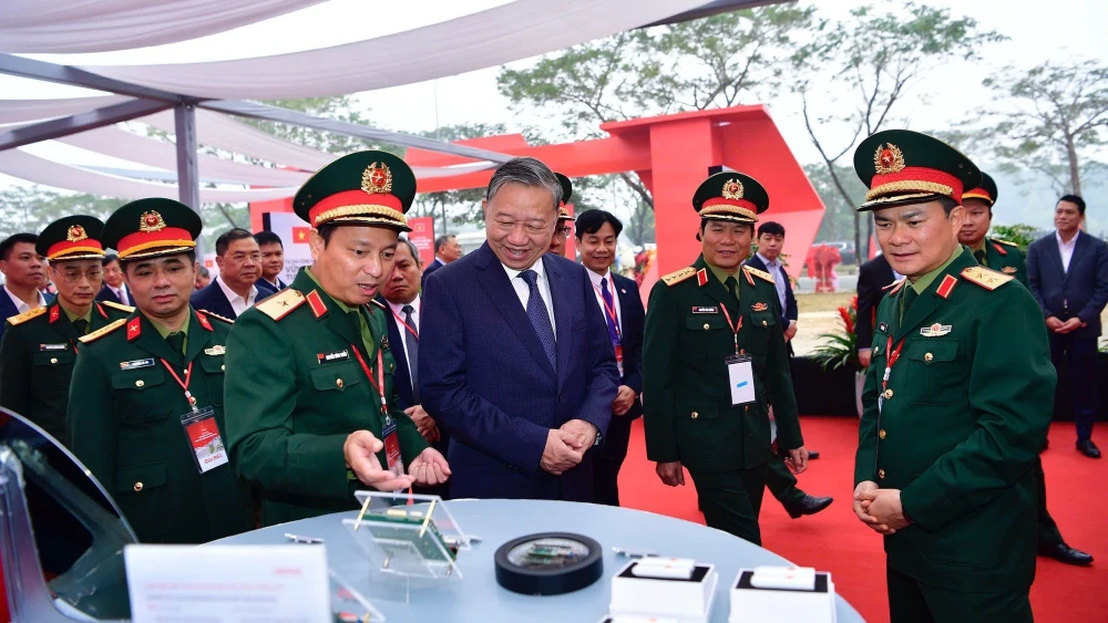 Tổng bí thư Tô Lâm nghe giới thiệu về công nghệ chip bán dẫn tại khu vực triển lãm của Viettel trong lễ khởi công nhà máy chip đầu tiên của Việt Nam.