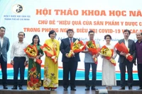 Đại biểu tham dự hội thảo tặng hoa chúc mừng các nhà nghiên cứu ứng dụng thuốc y học cổ truyền vào thực tế