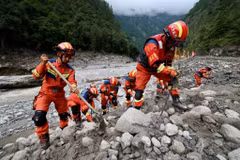 Các nhân viên cứu hộ Trung Quốc tìm kiếm thi thể các nạn nhân dưới các đống bùn và đất đá. Ảnh: Reuters.