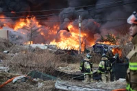 Ngày 16/1, các nhân viên cứu hỏa hướng mắt về phía đám cháy đang bao trùm làng Guryong, khu ổ chuột cuối cùng ở quận Gangnam, Seoul, Hàn Quốc. Ảnh: Reuters.