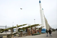 Người dân đi dạo gần các tên lửa của Iran trong một công viên tại Tehran, Iran ngày 26/3 Ảnh: Reuters.