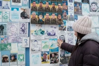 Bà Oksana Borkun ngắm nhìn bức chân dung chồng mình trên bức tường tưởng niệm những người lính Ukraine đã hy sinh ở Kiev, Ukraine. Ảnh: CNN.