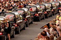 Người dân bày tỏ sự thương tiếc khi thi thể của 7 binh sĩ Anh thiệt mạng ở Afghanistan được đưa qua đường ở Wootton Bassett, Anh vào ngày 29/6/2010. Ảnh: Getty.