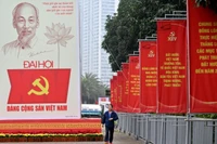 Một người đàn ông đi ngang qua bảng quảng cáo Đại hội Đảng Cộng sản Việt Nam lần thứ 14 bên ngoài Trung tâm Hội nghị Quốc gia ở Hà Nội vào ngày 15/1. Ảnh: AFP.