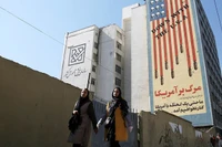 Hai phụ nữ đi qua một biểu ngữ nội dung chống Mỹ ở Tehran, Iran. Ảnh: Getty.
