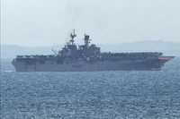 Tàu tấn công đổ bộ USS Tripoli (LHA-7) tiến vào eo biển Singapore, nhìn từ Singapore, hôm thứ Ba, ngày 17/ 3. Ảnh: Reuters.