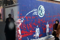 Người dân đi ngang qua những bức tranh tường có nội dung phản đối Mỹ ở Tehran, Iran. Ảnh: Getty.