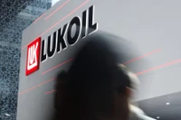Một người đi ngang qua logo của Lukoil trong sự kiện thường niên Triển lãm và Hội nghị Dầu khí Quốc tế Abu Dhabi (ADIPEC) tại Abu Dhabi, UAE ngày 3/11/2025. Ảnh: Reuters.