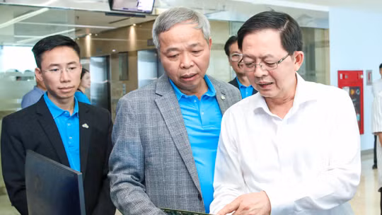 Chủ tịch CMC Nguyễn Trung Chính giới thiệu với Phó Thủ tướng Hồ Quốc Dũng (phải) về các sản phẩm, giải pháp công nghệ của CMC. Ảnh: CMC.