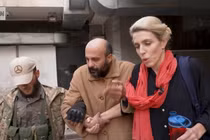 Hình ảnh tù nhân (giữa) được nhà báo Clarissa Ward (phải) của CNN và một người đàn ông có vũ trang hộ tống khỏi nhà giam ở Syria. Ảnh: CNN.