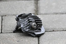 Một mảnh động cơ máy bay không người lái gần một tòa nhà dân cư bị thiệt hại ở Zapadny Kvartal, Vidnoye, Nga. Ảnh: Sputnik.