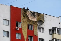 Cảnh sát đứng trên mái của một tòa nhà dân cư nhiều tầng bị hư hại trong cuộc tấn công bằng UAV của Ukraine ngày 11/3. Ảnh: Reuters.