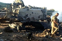 Binh sĩ Lebanon đi cạnh một máy đào bị phá hủy sau cuộc không kích của Israel. Ảnh: AFP.