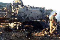 Binh sĩ Lebanon đi cạnh một máy đào bị phá hủy sau cuộc không kích của Israel. Ảnh: AFP.
