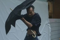 Một người đàn ông vật lộn với chiếc ô khi đi bộ ngược gió mạnh khi cơn bão Wipha tiến gần đến Hong Kong, Trung Quốc vào ngày 20/7. Ảnh: Reuters.