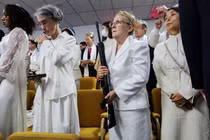 Một người phụ nữ cầm súng trường kiểu AR-15 khi mọi người tham dự buổi lễ tại Nhà thờ Sanctuary ở Newfoundland, Pennsylvania, Mỹ (Ảnh: Reuters)