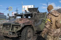 Một binh sĩ Nga kiểm tra xe quân sự bị hư hại ở Kharkiv, Ukraine ngày 27/2 (Ảnh: AP)