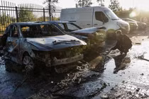 Một cảnh sát làm việc gần những chiếc xe bị hư hại tại hiện trường một tòa nhà dân cư bị hư hại trong cuộc tấn công bằng UAV và tên lửa của Nga, trong bối cảnh Nga tấn công Ukraine, ở ngoại ô Kiev, Ukraine, ngày 20/9. Ảnh: Reuters.