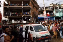 Một xe cứu thương đi qua gần hiện trường sau khi một máy bay huấn luyện của không quân đâm vào khuôn viên trường Cao đẳng Milestone, tại Dhaka, Bangladesh vào ngày 21/7. Ảnh: Reuters.