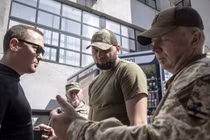 Các sĩ quan tuyển dụng kiểm tra giấy tờ của khi họ tìm kiếm những người đàn ông trong độ tuổi chiến đấu ở Kharkov, Ukraine. Ảnh: Getty.