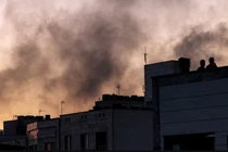 Người dân Iran đứng trên nóc tòa nhà giữa làn khói bốc lên nghi ngút sau cuộc không kích của Israel nhằm vào Tehran, thủ đô Iran, ngày 17/6. Ảnh: AFP.