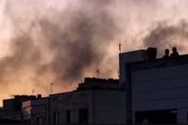 Người dân Iran đứng trên nóc tòa nhà giữa làn khói bốc lên nghi ngút sau cuộc không kích của Israel nhằm vào Tehran, thủ đô Iran, ngày 17/6. Ảnh: AFP.