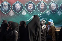 Những người phụ nữ đứng gần một tấm biển quảng cáo có hình ảnh của các quan chức quân sự và nhà khoa học Iran quá cố ở Tehran, Iran. Israel đã tấn công vào các cơ sở hạt nhân và quân sự của Iran, nhắm vào các tướng lĩnh và nhà khoa học. Ảnh: WSJ.