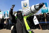 Một phụ nữ Yemen giơ cao một tên lửa giả được trang trí bằng màu cờ Palestine trong một cuộc biểu tình ở Sanaa vào ngày 15/1. Ảnh: AFP.