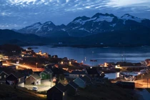 Những ngôi nhà lên đèn sau khi mặt trời lặn ở Tasiilaq, Greenland. Ảnh: Getty.