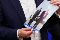 Tổng thống Mỹ Donald Trump cầm bức ảnh chụp ông và Tổng thống Nga Vladimir Putin trong cuộc gặp ở Alaska khi đang phát biểu tại Phòng Bầu dục của Nhà Trắng hôm 22/8. Ảnh: Reuters.
