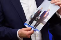 Tổng thống Mỹ Donald Trump cầm bức ảnh chụp ông và Tổng thống Nga Vladimir Putin trong cuộc gặp ở Alaska khi đang phát biểu tại Phòng Bầu dục của Nhà Trắng hôm 22/8. Ảnh: Reuters.