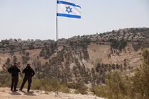 Lá cờ Israel tung bay, một phần của khu định cư Maale Adumim của Israel có thể được nhìn thấy ở phía sau, tại khu Bờ Tây do Israel chiếm đóng, ngày 14/8. Ảnh: Reuters.