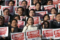 Các nhà lập pháp Hàn Quốc giơ cao biểu ngữ "Yoon Suk Yeol nên từ chức" vào ngày 4/12. Ảnh: Getty.