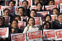 Các nhà lập pháp Hàn Quốc giơ cao biểu ngữ "Yoon Suk Yeol nên từ chức" vào ngày 4/12. Ảnh: Getty.