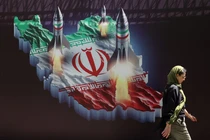 Một phụ nữ Iran đi ngang qua biểu ngữ chống Israel có hình tên lửa Iran trên đường phố ở Tehran, Iran ngày 19/4/2024 (Ảnh: Reuters)