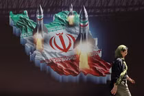 Một phụ nữ Iran đi ngang qua biểu ngữ chống Israel có hình tên lửa Iran trên đường phố ở Tehran, Iran ngày 19/4/2024 (Ảnh: Reuters)