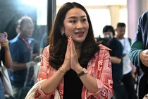 Thủ tướng Thái Lan Paetongtarn Shinawatra cầm túi xách khi đến trụ sở đảng ở Bangkok vào ngày 14/5/2023. Ảnh: AFP.
