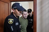 Các sĩ quan cảnh sát áp giải nghi phạm trong vụ sát hại nhà lập pháp Ukraine Andriy Parubiy vào phòng xử án ở Lviv, Ukraine, ngày 2/9. Ảnh: Reuters.