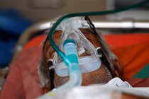 Một bệnh nhân được cho thở bình oxy trong xe cấp cứu, chờ được nhập viện điều trị COVID-19 (Ảnh: Reuters)