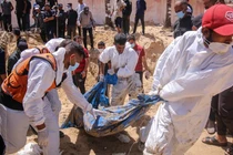 Nhân viên y tế Palestine kéo các thi thể bị chôn vùi từ một ngôi mộ tập thể tại khu liên hợp Y tế Nasser ở Khan Younis, Gaza vào ngày 21/4 (Ảnh: Getty)