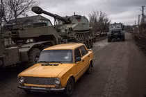 Xe Lada vượt qua xe vận tải quân sự mang lựu pháo ở khu vực Donetsk của Ukraine ngày 26/12/2024. Ảnh: WP.