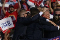 Donald Trump được nhân viên Mật vụ dẫn đi sau khi có tiếng súng vang lên tại cuộc vận động tranh cử ở Butler, Pennsylvania (Ảnh: AFP)