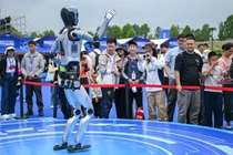Du khách xem một chú robot biểu diễn trong lễ hội robot thế giới ở Vũ Hán tuần này. Ảnh: Xinhua.