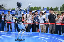 Du khách xem một chú robot biểu diễn trong lễ hội robot thế giới ở Vũ Hán tuần này. Ảnh: Xinhua.