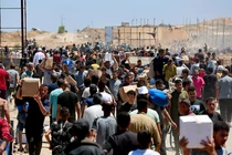 Người dân Palestine mang theo hàng viện trợ mà họ nhận được từ Quỹ Nhân đạo Gaza do Mỹ hậu thuẫn, tại trung tâm Dải Gaza, ngày 29/5. Ảnh: Reuters.